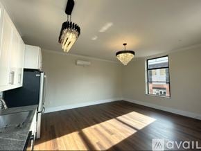 Elmira apartment for rent - A well-lit, empty room with wooden floors and a large window.