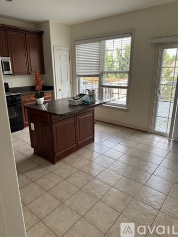 Stephens City townhouse for rent - A kitchen with brown cabinets and a black countertop.