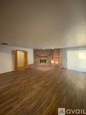 Oklahoma City house for rent - A room with wooden floors and a stone fireplace.