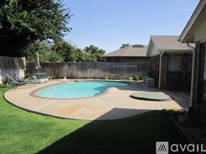 Oklahoma City house for rent - A backyard with a pool and a hot tub.