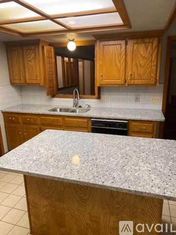 Oklahoma City house for rent - A kitchen with wooden cabinets and a granite countertop.