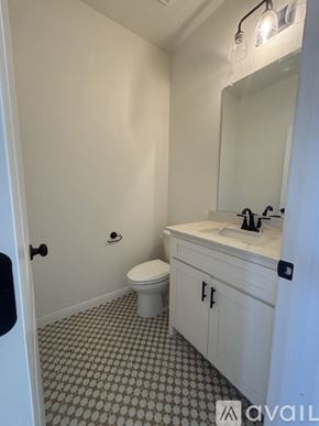 Poolville townhouse for rent - A bathroom with a toilet, sink, and mirror.