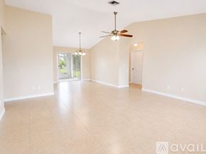 Cape Coral house for rent - A pool surrounded by a fence and a house in the background.