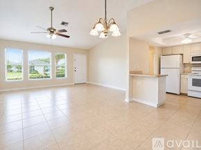 Cape Coral house for rent - A large, empty room with a kitchenette and a chandelier.