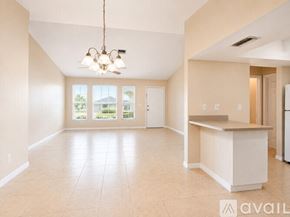 Cape Coral house for rent - A spacious room with tiled flooring and a ceiling fan.