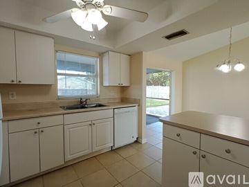 Cape Coral house for rent - A kitchen with white cabinets and a sink.