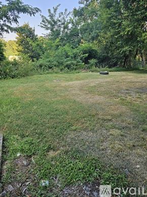Pittsburgh apartment for rent - A grassy field with trees in the background and a fence on the left side.