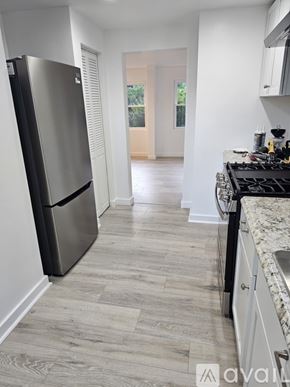 Pittsburgh apartment for rent - A kitchen with a black fridge and a wooden floor.