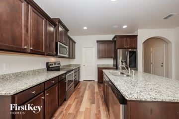 Murfreesboro house for rent - A kitchen with brown cabinets and a FirstKey Homes logo.
