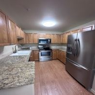 Post Falls apartment for rent - A kitchen with a refrigerator, oven, microwave, and sink.