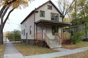 Fargo house for rent - A house with a brown front porch and a brown fence.