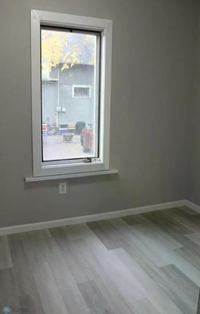 Fargo house for rent - A room with a window and wooden flooring.