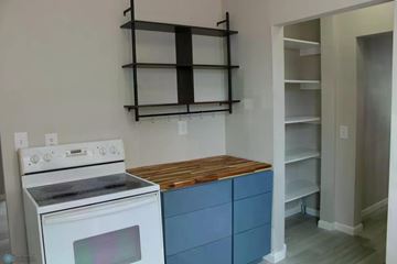 Fargo house for rent - A kitchen with a white stove and blue drawers.
