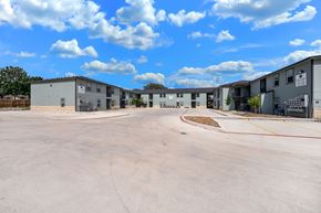 San Antonio apartment for rent - A parking lot with several buildings in the background.