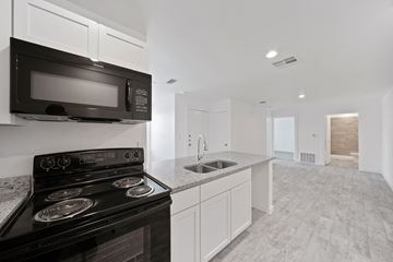 San Antonio apartment for rent - A modern kitchen with a black stove and microwave.