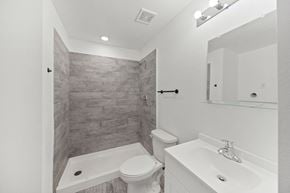 San Antonio apartment for rent - A bathroom with a toilet, sink, and a tiled shower.