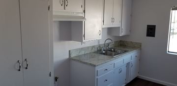 Cudahy apartment for rent - A kitchen with white cabinets and a marble countertop.