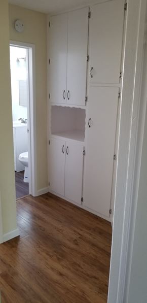 Cudahy apartment for rent - A room with a white door and a white cabinet with a shelf.