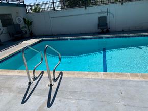 Cudahy apartment for rent - A pool with a diving board and a chair.