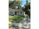 Mobile house for rent - A house with a brown roof and a white door is surrounded by a grassy area.