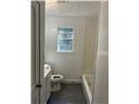 Mobile house for rent - A white door is open to a small bathroom with a toilet and sink.