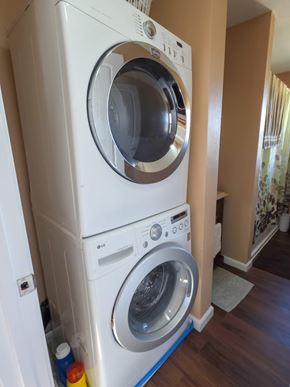 Walsenburg house for rent - A white front load washing machine with a top load dryer on top.