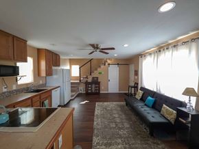 Walsenburg house for rent - A kitchen with a refrigerator, sink, and a counter with a microwave on it.