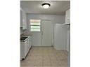 Mobile house for rent - A kitchen with white appliances and a white door.