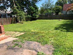 Hartford house for rent - A backyard with a grassy area and a brick pathway.