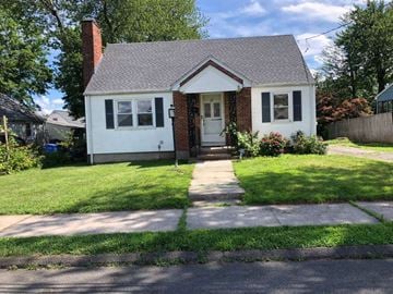 Hartford house for rent - A small white house with a brick chimney and a grey roof.