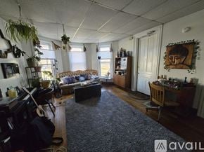 Kalamazoo apartment for rent - A living room with a couch, a guitar, and a backpack on the floor.