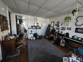 Kalamazoo apartment for rent - A room with a grey carpet and a piano.