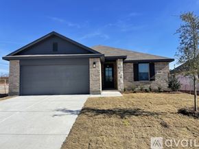 Anna house for rent - A house with a grey garage door and a brown brick exterior.