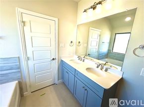 Anna house for rent - A bathroom with a white door, a white sink, and a mirror.
