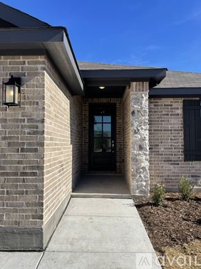 Anna house for rent - A house entrance with a stone pillar and a black door.
