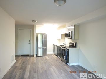 Seattle apartment for rent - A kitchen with a refrigerator, microwave, and oven is available for rent.