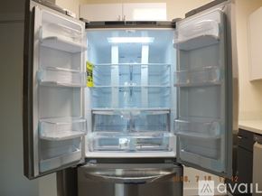 Seattle apartment for rent - A refrigerator with its door open showing empty shelves.