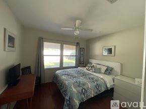 Los Angeles house for rent - A bedroom with a bed, desk, and window.