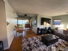 Los Angeles house for rent - A living room with a black coffee table and a flat screen TV mounted on the wall.