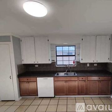 Pensacola apartment for rent - A kitchen with white cabinets and brown countertops.