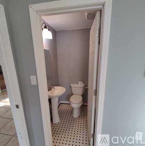 Pensacola apartment for rent - A small bathroom with a toilet, sink, and a pink wall.