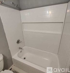 Pensacola apartment for rent - A white bathroom with a toilet, tub, and shower.