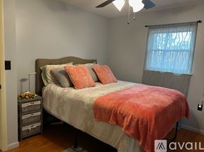 Eureka Springs house for rent - A bedroom with a bed, pillows, and a ceiling fan.