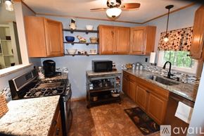 Eureka Springs house for rent - A kitchen with a black stove top oven and a black microwave.