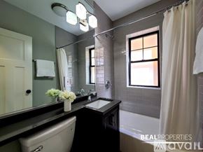 Chicago apartment for rent - A bathroom with a sink, mirror, and shower.