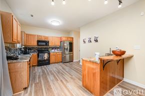 Raleigh house for rent - A kitchen with wooden cabinets and a black stove top oven.