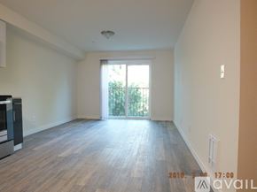 Seattle apartment for rent - A room with wooden flooring and a window with a view of trees.
