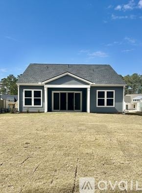 Hardeeville house for rent - A grey house with a black roof and a white garage door.