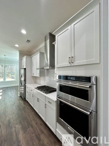 Hardeeville house for rent - A modern kitchen with stainless steel appliances and white cabinets.