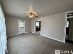 Petersburg house for rent - A spacious room with a ceiling fan and carpeted floor.